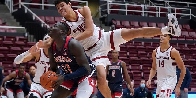 Arizona center Oumar Ballo (11) is fouled by Stanford forward Brandon Angel, 上, during the second half of an NCAA college basketball game in Stanford, カリフォルニア, 木曜日, 1月. 20, 2022.