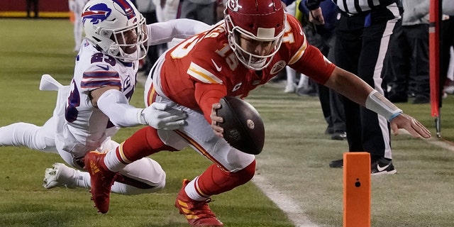 Kansas City Chiefs quarterback Patrick Mahomes scores on an 8-yard touchdown run ahead of Buffalo Bills safety Micah Hyde during the first half of an NFL divisional round playoff football game, Sunday, Jan. 23, 2022, in Kansas City, Missouri.