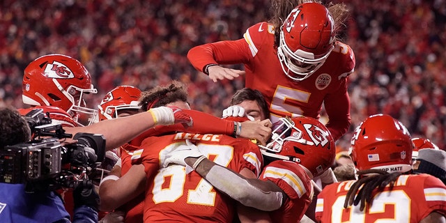 Kansas City Chiefs tight end Travis Kelce (87) celebrates with teammates after catching an 8-yard touchdown pass during overtime in an NFL divisional round playoff football game against the Buffalo Bills, Sondag, Jan.. 23, 2022, in Kansas City, Mo. The Chiefs won 42-36.