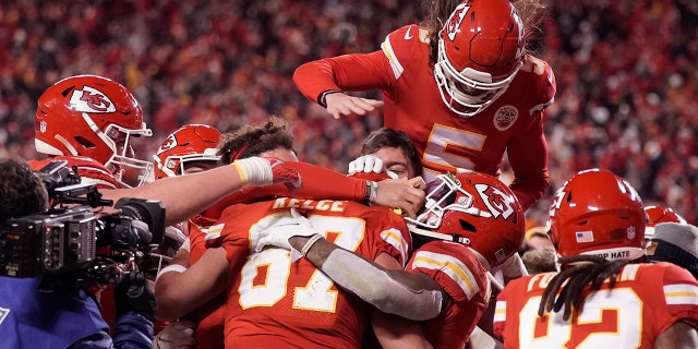 Kansas City Chiefs tight end Travis Kelce (87) celebrates with teammates after catching an 8-yard touchdown pass during overtime in an NFL divisional round playoff football game against the Buffalo Bills, Sondag, Jan.. 23, 2022, in Kansas City, Mo. The Chiefs won 42-36.