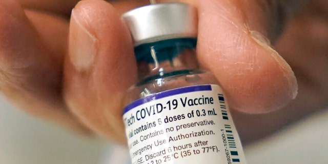 Dr. Manjul Shukla transferred the Pfizer COVID-19 vaccine to a syringe at a mobile vaccination clinic in Worcester, Massachusetts on Thursday, December 2, 2021.