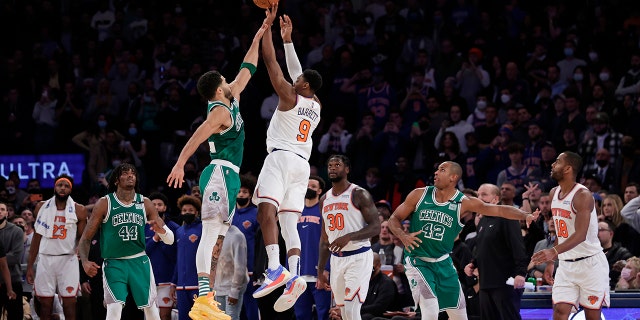 New York Knicks guard RJ Barrett (9) makes the game-winning 3-point basket in front of Boston Celtics forward Jayson Tatum during an NBA basketball game Thursday, Jan.. 6, 2022, In New York. The Knicks won 108-105.