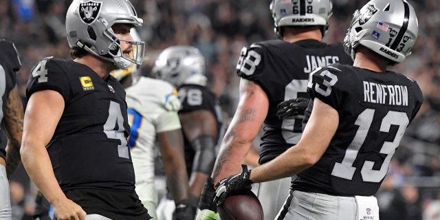 Las Vegas Raiders quarterback Derek Carr (4) celebrates after wide receiver Hunter Renfrow (13) scored a touchdown against the Los Angeles Chargers during the second half of an NFL football game, Sondag, Jan.. 9, 2022, in Las Vegas.