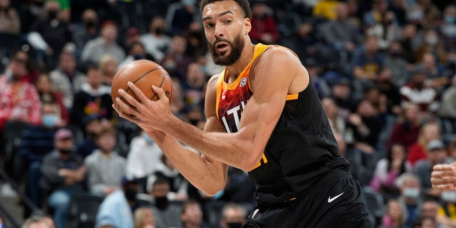Utah Jazz center Rudy Gobert pulls in a rebound in the first half of an NBA basketball game against the Denver Nuggets ,Sunday Jan. 16, 2022, a Denver.
