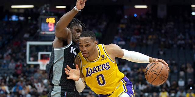 Los Angeles Lakers guard Russell Westbrook (0) tries to drive on Sacramento Kings guard Davion Mitchell, 剩下, in the first quarter of an NBA basketball game in Sacramento, 加州, 星期三, 一月. 12, 2022.