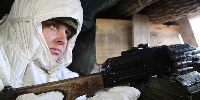 Um soldado assume sua posição em uma trincheira na linha de separação perto da vila de Yasen, a cerca de 33,6 km (21,2 milhas) a sudoeste de Donetsk, controlada por separatistas apoiados pela Rússia, leste da Ucrânia, sexta-feira, 14 de janeiro de 2022.