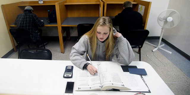 FILE - Rachel Barr, 17, of Scarborough, Maine, takes a pre SAT test in a room with other students at The Study Hall in Scarborough, Feb. 23, 2016. 