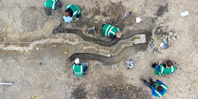 Paleontologists work at a site where remains of Britain's largest ichthyosaur were found, at Rutland Water, Rutland County, Britain, August 2021, in this picture obtained from social media on January 10, 2022. 