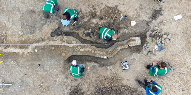 Paleontologists work at a site where remains of Britain's largest ichthyosaur were found, at Rutland Water, Rutland County, Britain, August 2021, in this picture obtained from social media on January 10, 2022.