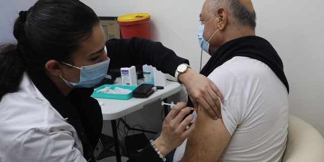 A man receives a dose of COVID-19 vaccine in central Israeli city of Modiin, on Jan. 12, 2022. (Photo by Gil Cohen Magen/Xinhua via Getty Images)