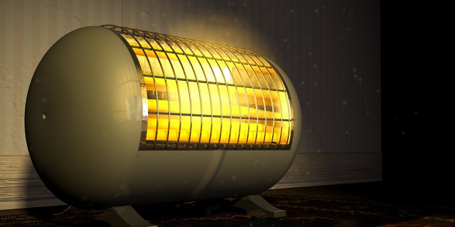 A cylindrical shaped electric heater illuminating and radiating in an old room.