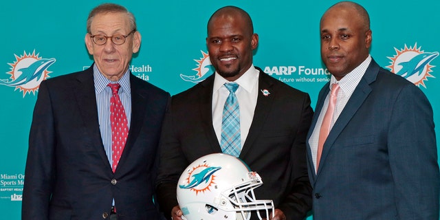 Chairman of the Board/Managing General Partner Stephen M. Ross, Head coach Brian Flores, and General Manager Chris Grier pose for a photograph after Flores was introduced as the new head coach of the Miami Dolphins on February 4, 2019 at the Miami Dolphins training facility in Davie, Florida.