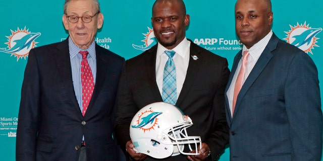 Chairman of the Board/Managing General Partner Stephen M. Ross, Head coach Brian Flores, and General Manager Chris Grier pose for a photograph after Flores was introduced as the new head coach of the Miami Dolphins on February 4, 2019 at the Miami Dolphins training facility in Davie, Florida.