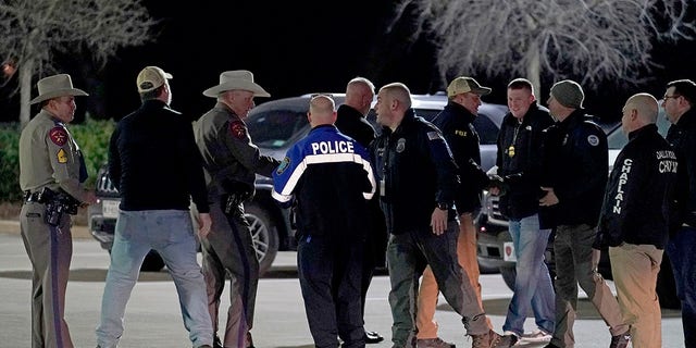 Law enforcement officials talk to each other after a news conference where they announced that all hostages at Congregation Beth Israel synagogue were safe and the hostage taker was dead on Saturday, Jan. 15, 2022, in Colleyville, Texas.