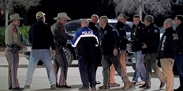 Law enforcement officials talk to each other after a news conference where they announced that all hostages at Congregation Beth Israel synagogue were safe and the hostage taker was dead on Saturday, Jan. 15, 2022, in Colleyville, Texas.