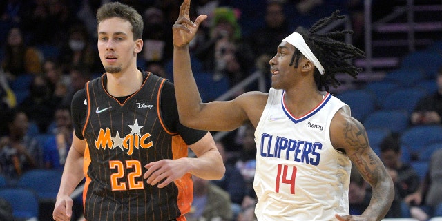 Los Angeles Clippers guard Terance Mann (14) celebrates after scoring a 3-pointer in front of Orlando Magic forward Franz Wagner (22) during the first half of an NBA basketball game, 수요일, 1 월. 26, 2022, 올랜도, Fla.