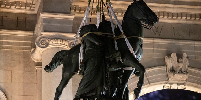 A crane carries away a portion of the statue of Theodore Roosevelt in front of the American Museum of Natural History in New York City, on Jan. 20, 2022.