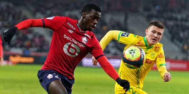 Timothy Weah of Lille OSC competes for the ball with Quentin Merlin of FC Nantes during the Ligue 1 Uber Eats match between Lille OSC and FC Nantes at Stade Pierre Mauroy on November 27, 2021 in Lille, France.