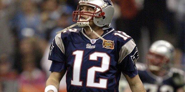 O quarterback Tom Brady do New England Patriots entra em campo durante o Super Bowl XXXVIII contra o Carolina Panthers no Reliant Stadium em 1 de fevereiro de 2004, em Houston.  Os Patriots derrotaram os Panthers por 32 a 29.