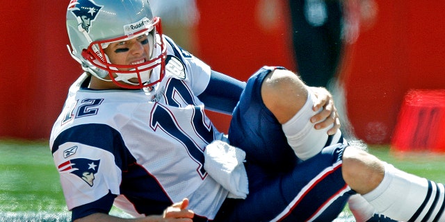 New England Patriots quarterback Tom Brady grimaces as he grabs his left knee after injuring it during a season opener against the Kansas City Chiefs at Gillette Stadium. 