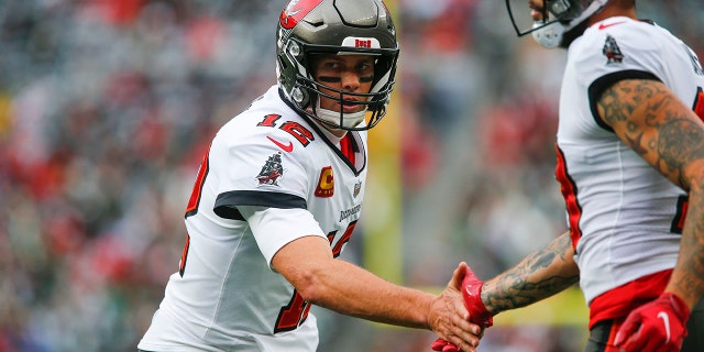 Tampa Bay Buccaneers quarterback Tom Brady celebrates with Mike Evans after Evans scored a touchdown against the New York Jets, Sunday, Jan. 2, 2022, in East Rutherford, New Jersey.
