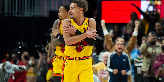 Trae Young, guardia degli Atlanta Hawks (11) and forward John Collins react after a 3-point basket during the second half of an NBA basketball game against the Los Angeles Lakers, Domenica, Jan. 30, 2022, ad Atlanta.