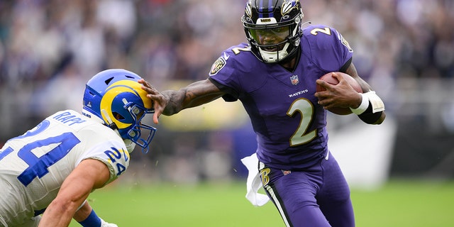 Ravens quarterback Tyler Huntley applies a stiff arm on Los Angeles Rams free safety Taylor Rapp while scrambling for yardage Sunday, Jan. 2, 2022, in Baltimore.