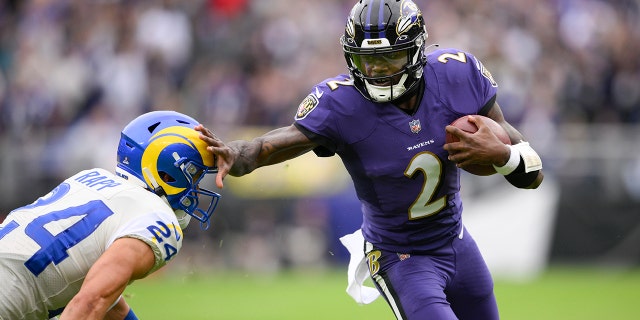 Ravens quarterback Tyler Huntley applies a stiff arm on Los Angeles Rams free safety Taylor Rapp while scrambling for yardage Sunday, Jan. 2, 2022, in Baltimore.