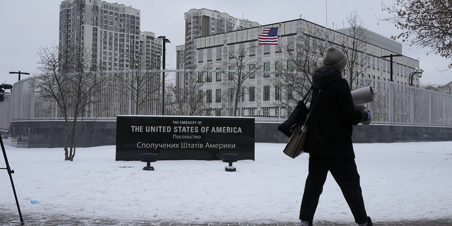 A woman walks past the U.S. Embassy in Kyiv, Ucraina, di lunedi.