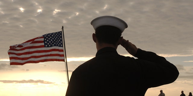 Sailors salute the American flag during the morning playing of the National Anthem before the maiden voyage of the USS San Antonio (LPD-17) amphibious transport dock after her commissioning ceremony. 