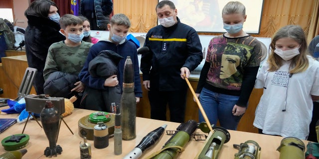 A police officer shows explosives to schoolchildren during a police-organized civilian safety lesson in a city school in Kyiv, Ukraine, on Thursday.