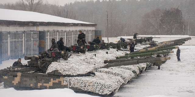 Ukrainian soldiers examine their tanks at a military unit close to Kharkiv, Ukraine, on Monday.