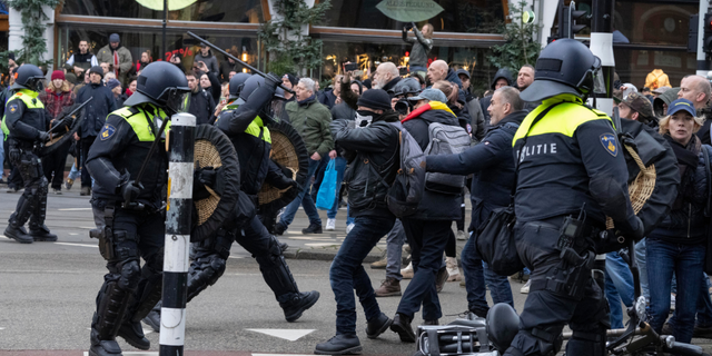 Police clash with demonstrators as thousands of people defied a ban Sunday to gather and protest the Dutch government's coronavirus lockdown measures, in Amsterdam, Netherlands, Sunday, Jan. 2, 2022. (AP Photo/Peter Dejong)