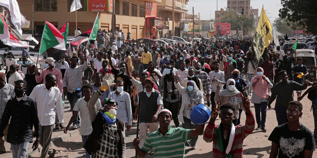 People chant slogans during a protest to denounce the October military coup, in Khartoum, Sudan, Sunday, Jan. 2, 2022. Sudanese security forces fired tear gas Sunday to disperse protesters as thousands rallied against military rule, medics said. (AP Photo/Marwan Ali)