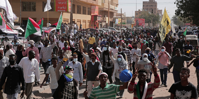 People chant slogans during a protest to denounce the October military coup, in Khartoum, Sudan, Sunday, Jan. 2, 2022. Sudanese security forces fired tear gas Sunday to disperse protesters as thousands rallied against military rule, medics said. (AP Photo/Marwan Ali)