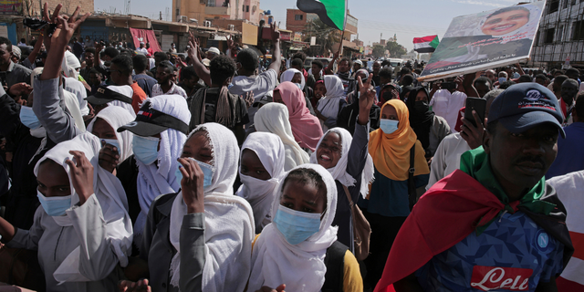 People chant slogans during a protest to denounce the October 2021 military coup, in Khartoum, Sudan, Sunday, Jan. 2, 2022. Sudanese security forces fired tear gas Sunday to disperse protesters as thousands rallied against military rule, medics said. (AP Photo/Marwan Ali)