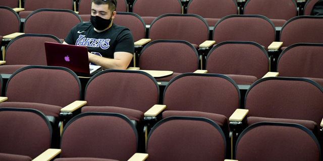 A UNLV student takes notes as he attends a criminal justice class taught amid the spread of the coronavirus in September 2020 in Las Vegas.