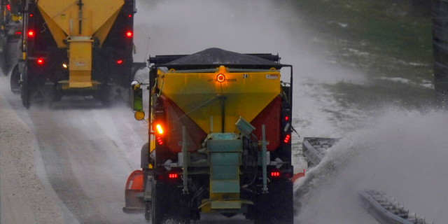 Snow plows remove snow and ice from Interstate 85/40 as a winter storm moves through the area near Hillsborough, N.C., Sunday, Jan. 16, 2022. (AP Photo/Gerry Broome)