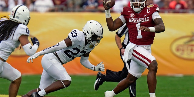 Arkansas quarterback KJ Jefferson (1) eludes Penn State linebacker Curtis Jacobs (23) during the first half of the Outback Bowl NCAA college football game Saturday, Jan. 1, 2022, in Tampa, Fla.