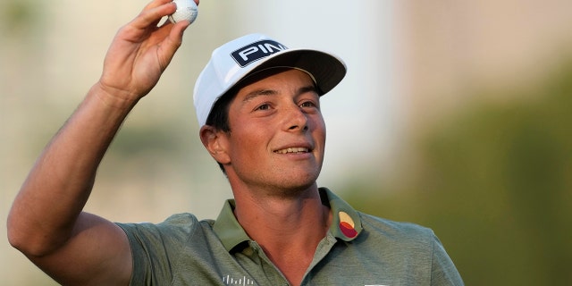 Viktor Hovland of Norway throws a ball after he won the Dubai Desert Classic golf tournament in Dubai, United Arab Emirates, Sunday, Jan. 30, 2022.