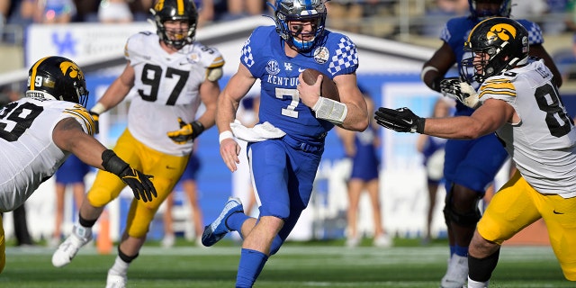 Kentucky quarterback Will Levis (7) scrambles for yardage between Iowa defensive linemen Noah Shannon (99), Zach VanValkenburg (97) and Logan Lee (85) during the second half of the Citrus Bowl Saturday, Jan. 1, 2022, in Orlando, Fla.