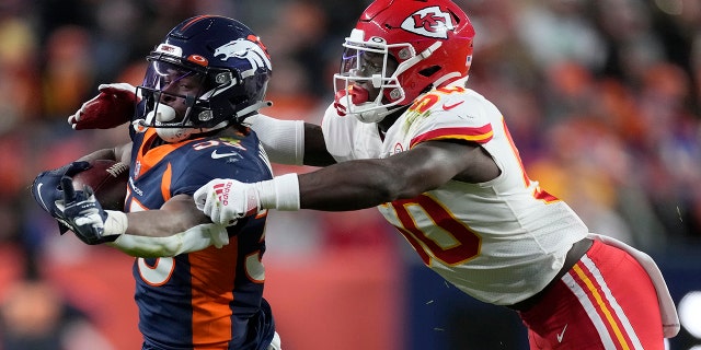 Denver Broncos running back Javonte Williams, links, runs against Kansas City Chiefs middle linebacker Willie Gay during the second half of an NFL football game Saturday, Jan.. 8, 2022, in Denver.