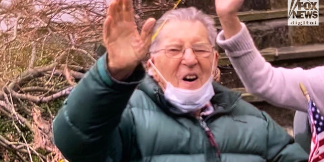 Veteran Stanley Tauber waves on his 102nd birthday to friends and fellow residents of his small town in New York who came out to honor him on Dec. 31. 2021.