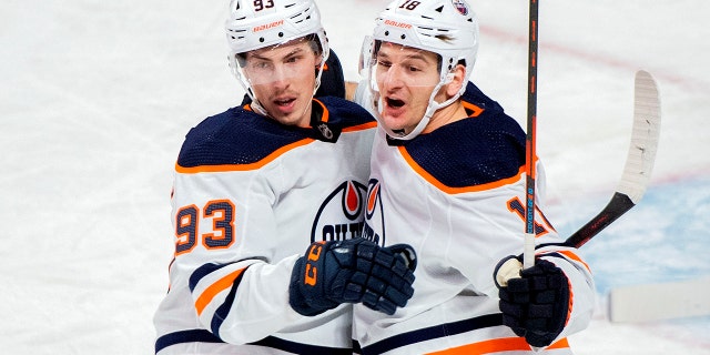 Edmonton Oilers' Zach Hyman (18) celebrates his goal with teammate Ryan Nugent-Hopkins (93) during first-period NHL hockey game action against the Montreal Canadiens in Montreal, Saterdag, Jan.. 29, 2022.