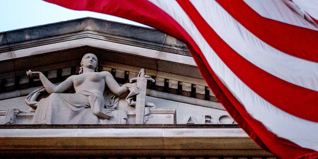 An American flag flies outside the Department of Justice in Washington, March 22, 2019. 