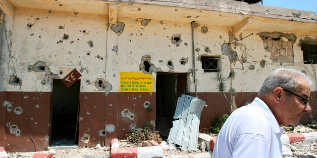 A Lebanese man walks past the damaged former Israeli Khiam prison, Aug. 16, 2006, in the southern town of Khiam, Lebanon, that was attacked during the monthlong Israeli forces' offensive.
