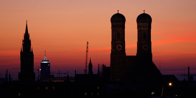 The sun goes down behind the Church of Our Lady, right, the city hall and Church Alter Peter in Munich, southern Germany, Sept. 28, 2008. 