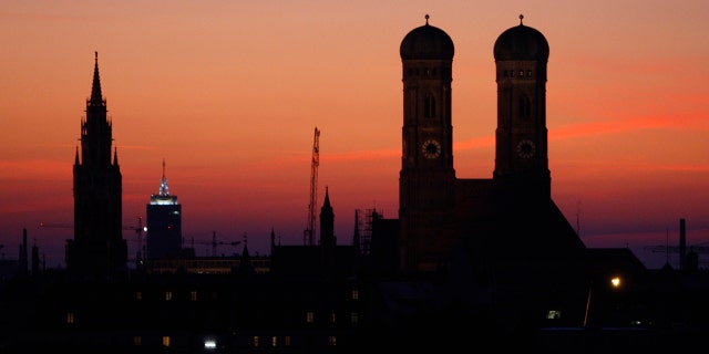 The sun goes down behind the Church of Our Lady, right, the city hall and Church Alter Peter in Munich, southern Germany, Sept. 28, 2008.