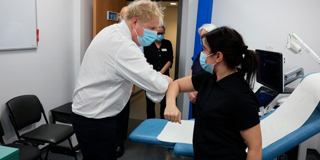 Britain's Prime Minister Boris Johnson, left, greets a member of staff during a visit to Finchley Memorial Hospital in North London, Tuesday, Jan. 18, 2022.