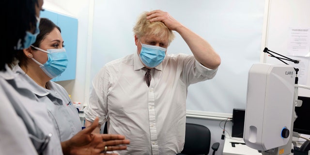 Britain's Prime Minister Boris Johnson, center, gestures during a visit to Finchley Memorial Hospital in North London, Tuesday, Jan. 18, 2022.